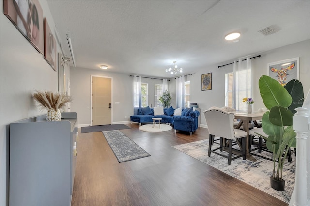 325 Aldridge Ln, Davenport, FL 33897 - living room featuring a chandelier, wood finished floors, a textured ceiling, and baseboards