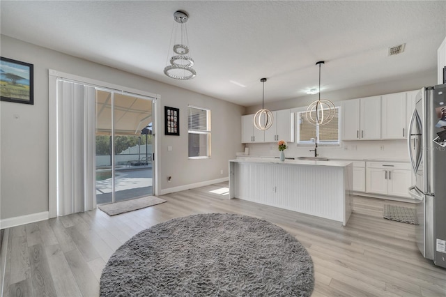 325 Aldridge Ln, Davenport, FL 33897 - kitchen featuring baseboards, light wood finished floors, white cabinets, and light countertops