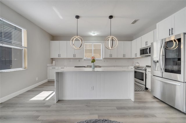 325 Aldridge Ln, Davenport, FL 33897 - kitchen featuring stainless steel appliances, a kitchen island, white cabinetry, light countertops, and baseboards