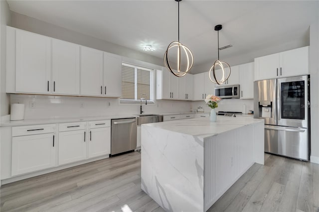 325 Aldridge Ln, Davenport, FL 33897 - kitchen with stainless steel appliances, a sink, light wood-style floors, and tasteful backsplash