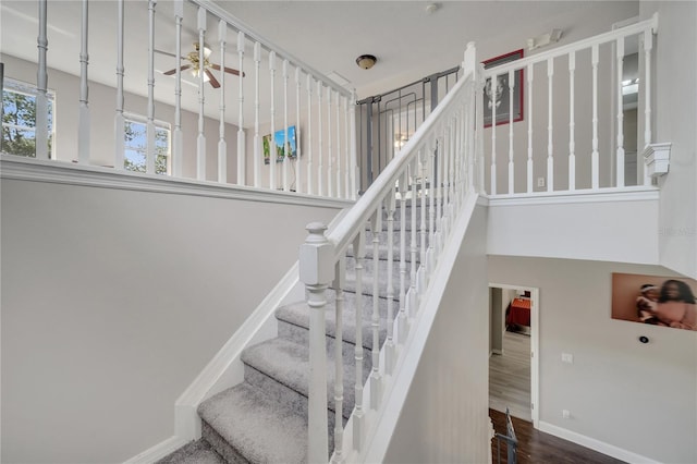 325 Aldridge Ln, Davenport, FL 33897 - stairs featuring wood finished floors, baseboards, a ceiling fan, and a high ceiling
