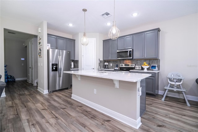 12133 Bracco St, Winter Garden, FL 34787 - kitchen featuring stainless steel appliances, dark wood-type flooring, backsplash, a breakfast bar area, and recessed lighting