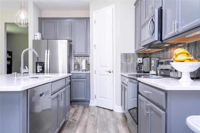 12133 Bracco St, Winter Garden, FL 34787 - kitchen featuring appliances with stainless steel finishes, gray cabinetry, and backsplash