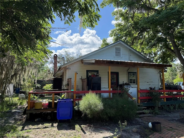 back of property featuring covered porch