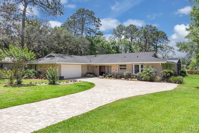 303 S Sweetwater Blvd, Longwood, FL 32779 - single story home featuring an attached garage, driveway, stucco siding, and a front lawn