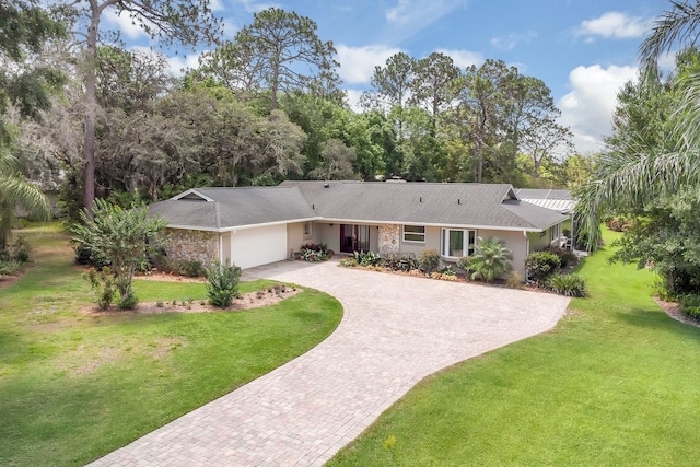 303 S Sweetwater Blvd, Longwood, FL 32779 - ranch-style home featuring decorative driveway, a garage, a front yard, and stucco siding
