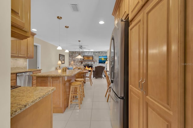303 S Sweetwater Blvd, Longwood, FL 32779 - kitchen featuring stainless steel appliances, a ceiling fan, a stone fireplace, a kitchen island, and open floor plan