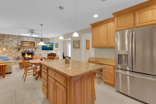 303 S Sweetwater Blvd, Longwood, FL 32779 - kitchen featuring stainless steel fridge with ice dispenser, a stone fireplace, ceiling fan, light tile patterned floors, and a kitchen island