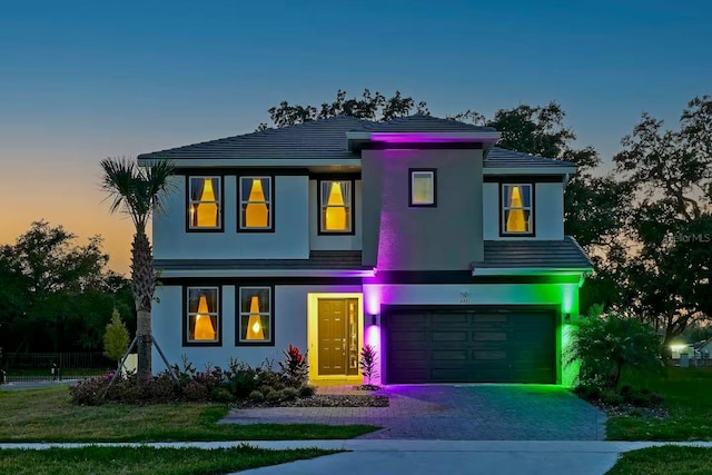 4441 Ganesha Loop, Kissimmee, FL 34746 - view of front facade featuring an attached garage, stucco siding, decorative driveway, and fence