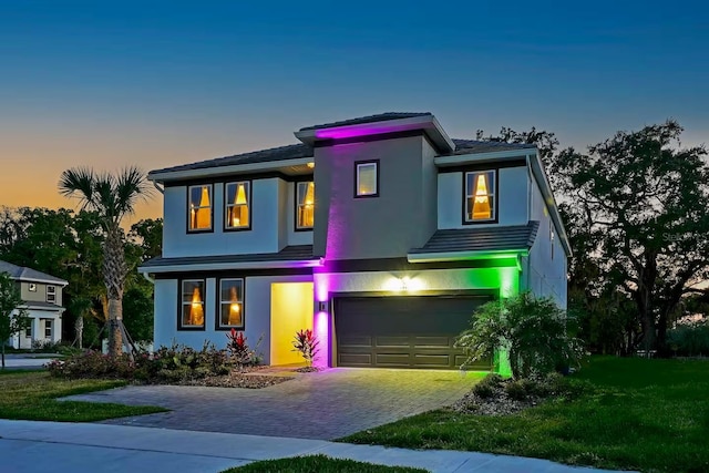4441 Ganesha Loop, Kissimmee, FL 34746 - view of front of house with an attached garage, decorative driveway, stucco siding, and a yard