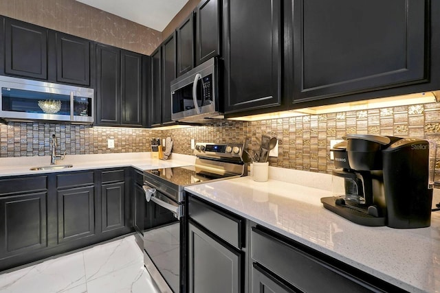 4441 Ganesha Loop, Kissimmee, FL 34746 - kitchen with appliances with stainless steel finishes, a sink, dark cabinets, and decorative backsplash