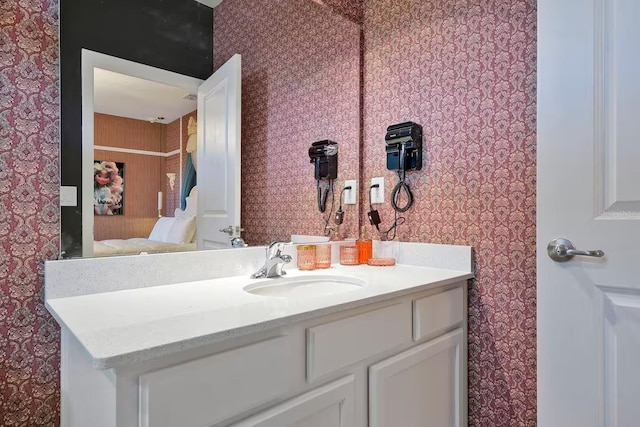 4441 Ganesha Loop, Kissimmee, FL 34746 - bathroom with wallpapered walls, ensuite bath, and vanity