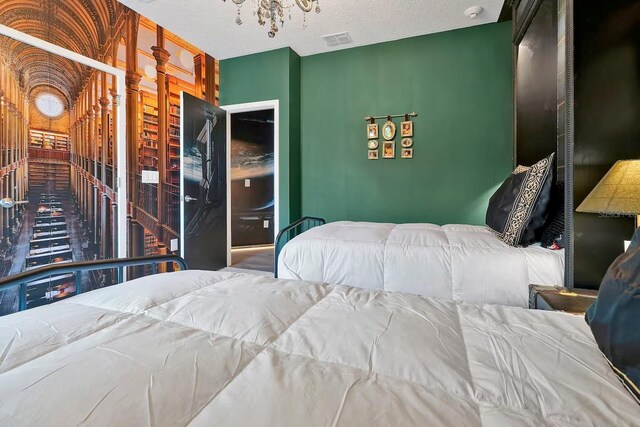 4441 Ganesha Loop, Kissimmee, FL 34746 - bedroom with a chandelier and a textured ceiling