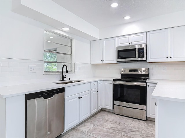 1113 Leeward Dr, Deltona, FL 32738 - kitchen featuring stainless steel appliances, a sink, recessed lighting, white cabinets, and decorative backsplash