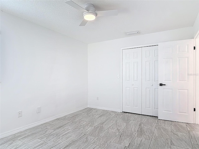 1113 Leeward Dr, Deltona, FL 32738 - unfurnished bedroom with a closet, a textured ceiling, ceiling fan, and baseboards