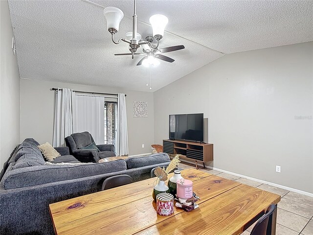 1803 Foxhall Cir Unit 1803, Kissimmee, FL 34741 - living area featuring lofted ceiling, a textured ceiling, light tile patterned flooring, ceiling fan, and baseboards