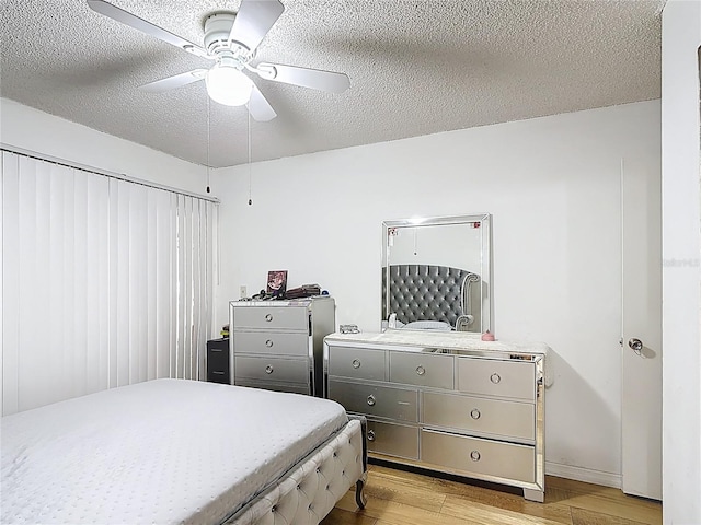 1803 Foxhall Cir Unit 1803, Kissimmee, FL 34741 - bedroom with light wood finished floors, a textured ceiling, a ceiling fan, and baseboards