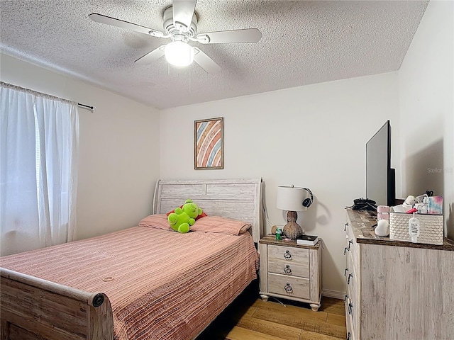 1803 Foxhall Cir Unit 1803, Kissimmee, FL 34741 - bedroom featuring light wood-style floors, a textured ceiling, and a ceiling fan