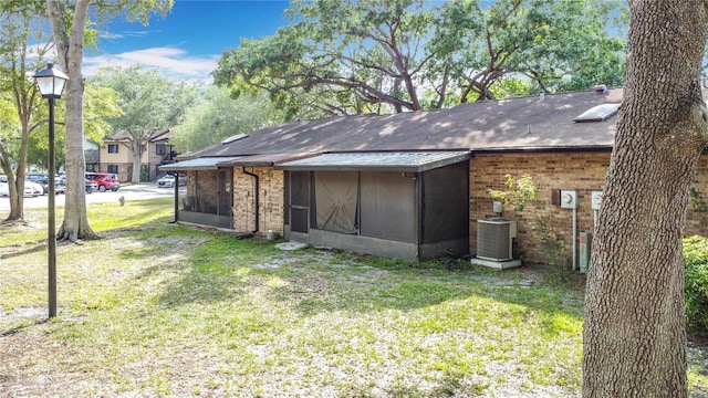 1803 Foxhall Cir Unit 1803, Kissimmee, FL 34741 - rear view of property with cooling unit, a sunroom, a lawn, and brick siding