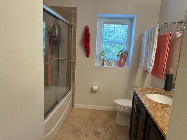10148 Malpas Pt, Orlando, FL 32832 - full bath with vanity, baseboards, toilet, bath / shower combo with glass door, and tile patterned flooring