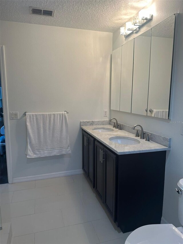 10148 Malpas Pt, Orlando, FL 32832 - bathroom with toilet, a textured ceiling, double vanity, and baseboards