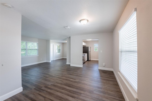 4226 Kelly Miller Ct, Orlando, FL 32811 - empty room featuring plenty of natural light, dark wood finished floors, baseboards, and a textured ceiling
