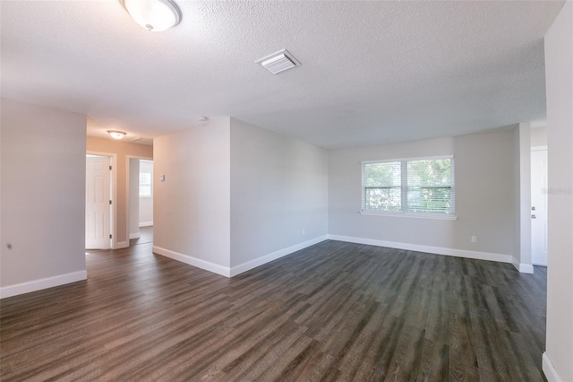 4226 Kelly Miller Ct, Orlando, FL 32811 - empty room featuring dark wood-style flooring, a textured ceiling, and baseboards