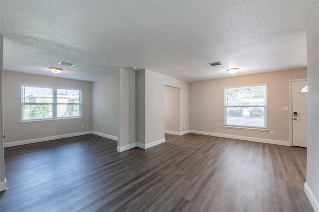 4226 Kelly Miller Ct, Orlando, FL 32811 - unfurnished living room featuring a textured ceiling, dark wood-style floors, and baseboards
