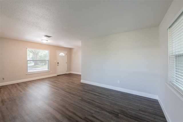 4226 Kelly Miller Ct, Orlando, FL 32811 - spare room featuring dark wood-type flooring, baseboards, and a textured ceiling