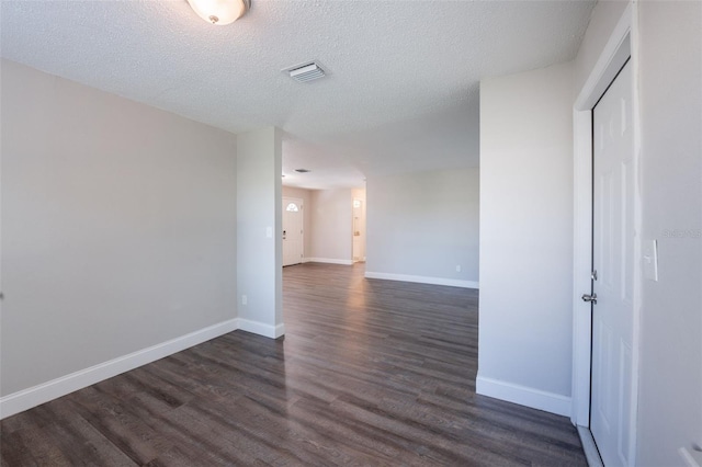 4226 Kelly Miller Ct, Orlando, FL 32811 - unfurnished room with dark wood finished floors, baseboards, and a textured ceiling