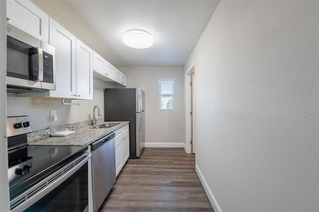 4226 Kelly Miller Ct, Orlando, FL 32811 - kitchen featuring stainless steel appliances, a sink, white cabinetry, baseboards, and dark wood finished floors