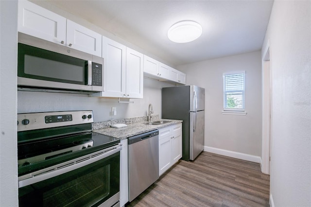 4226 Kelly Miller Ct, Orlando, FL 32811 - kitchen featuring appliances with stainless steel finishes, a sink, baseboards, and white cabinetry