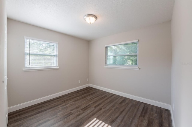 4226 Kelly Miller Ct, Orlando, FL 32811 - spare room with dark wood-style flooring, baseboards, and a textured ceiling