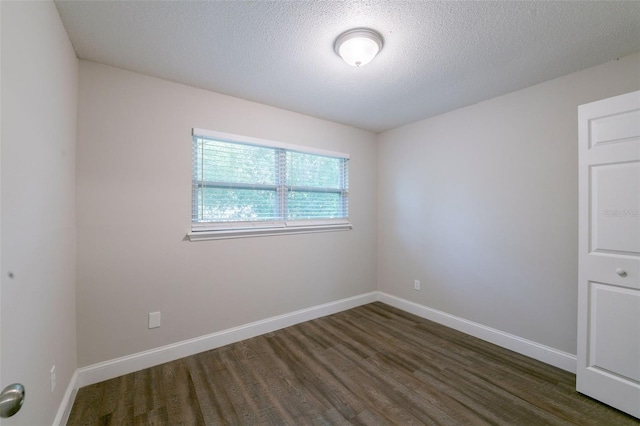 4226 Kelly Miller Ct, Orlando, FL 32811 - unfurnished room featuring dark wood finished floors, baseboards, and a textured ceiling