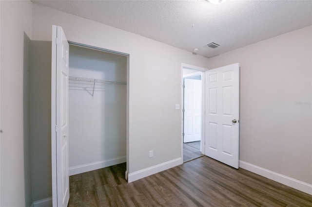4226 Kelly Miller Ct, Orlando, FL 32811 - unfurnished bedroom featuring wood finished floors, a closet, a textured ceiling, and baseboards