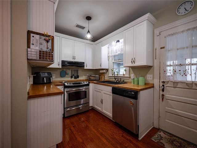 kitchen featuring appliances with stainless steel finishes, wooden counters, under cabinet range hood, and white cabinetry