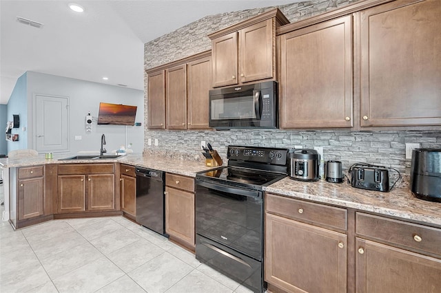503 Meadow Pointe Dr, Haines City, FL 33844 - kitchen with black appliances, a sink, a peninsula, tasteful backsplash, and light stone counters
