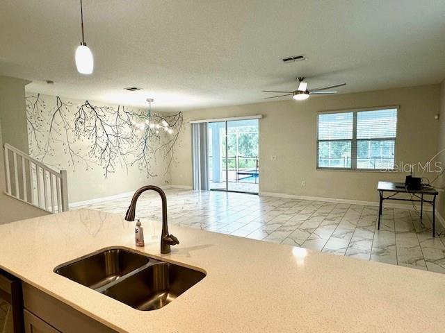 1513 Maidstone Ct, Davenport, FL 33896 - kitchen with a sink, light marble finish flooring, light countertops, and pendant lighting