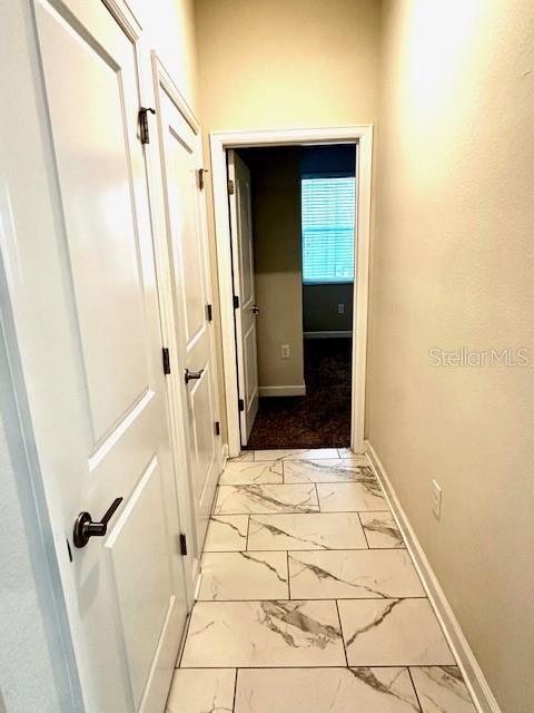 1513 Maidstone Ct, Davenport, FL 33896 - corridor with light marble finish flooring and baseboards