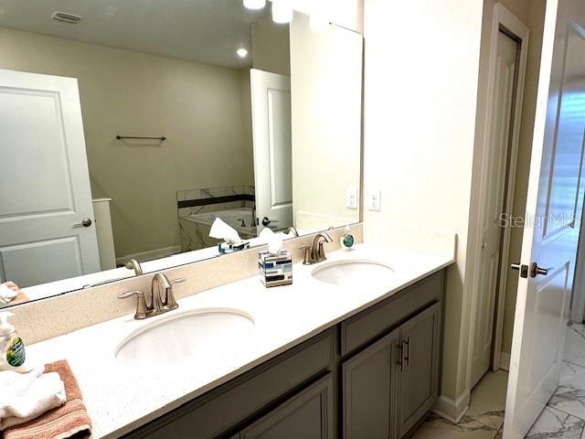 1513 Maidstone Ct, Davenport, FL 33896 - full bathroom with marble look tile flooring, double vanity, and recessed lighting