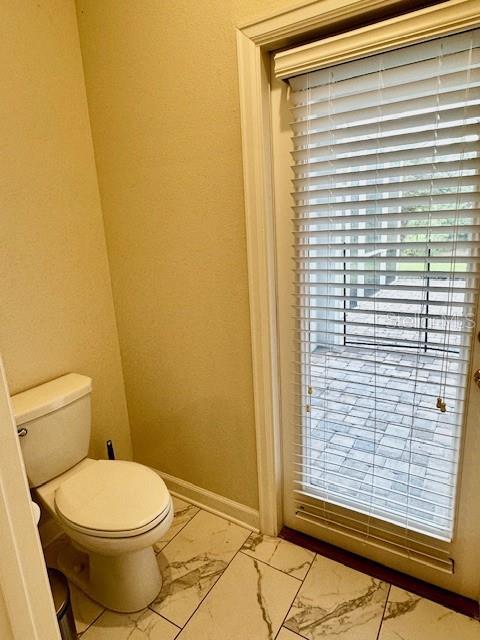 1513 Maidstone Ct, Davenport, FL 33896 - bathroom with marble finish floors, toilet, and baseboards