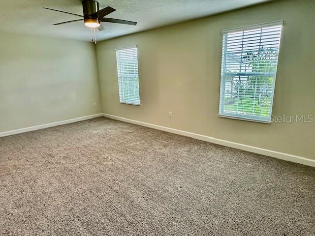 1513 Maidstone Ct, Davenport, FL 33896 - carpeted spare room with baseboards and a ceiling fan