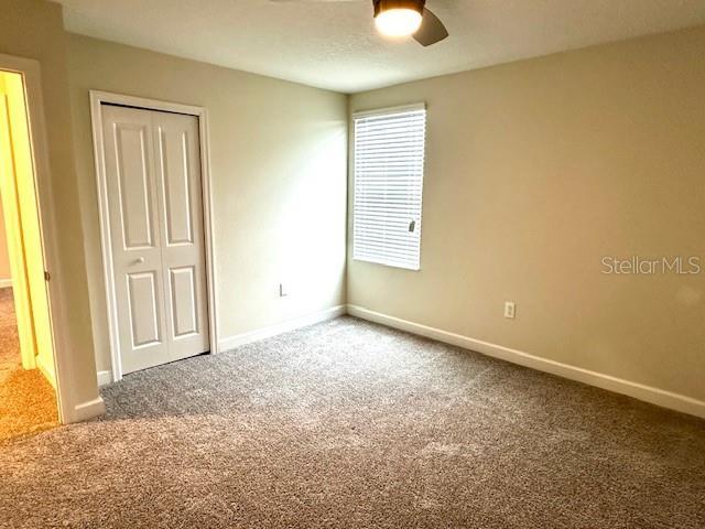 1513 Maidstone Ct, Davenport, FL 33896 - unfurnished bedroom featuring carpet floors, a closet, and baseboards