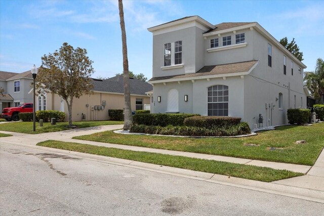 166 Minniehaha Cir, Haines City, FL 33844 - view of front facade with stucco siding, a front yard, and roof with shingles