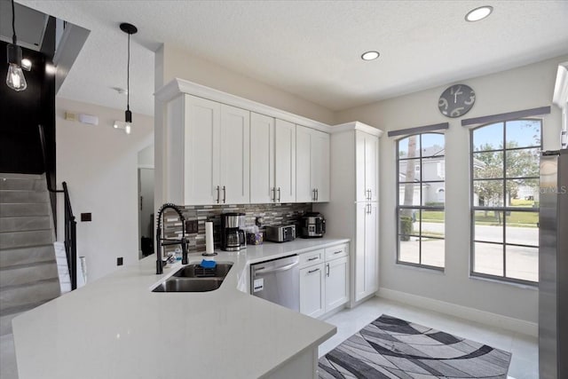 166 Minniehaha Cir, Haines City, FL 33844 - kitchen with a sink, stainless steel appliances, backsplash, light countertops, and white cabinetry