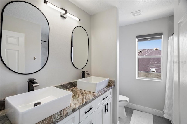 166 Minniehaha Cir, Haines City, FL 33844 - full bathroom featuring toilet, double vanity, baseboards, and a textured ceiling
