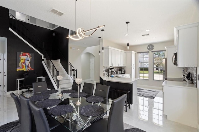 166 Minniehaha Cir, Haines City, FL 33844 - dining area with arched walkways, stairs, baseboards, and recessed lighting