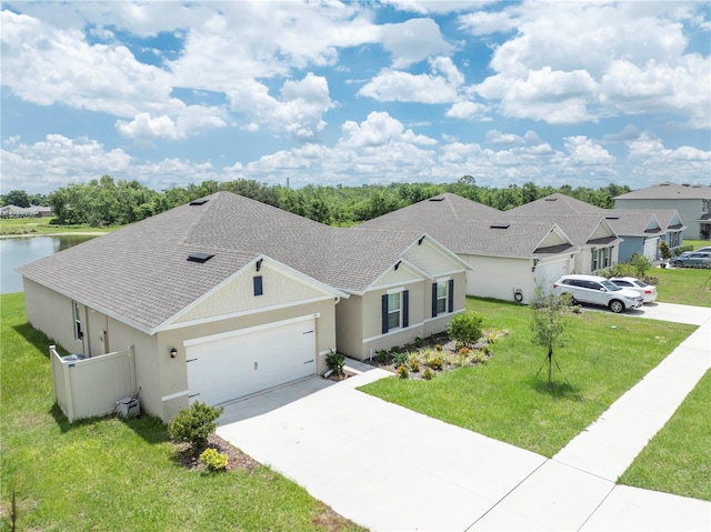 single story home with an attached garage, a shingled roof, concrete driveway, and a front yard