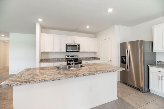 kitchen featuring appliances with stainless steel finishes, a sink, white cabinetry, a kitchen island with sink, and recessed lighting