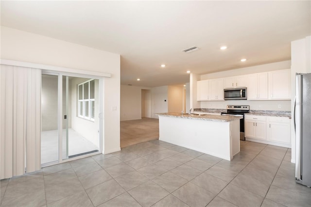 kitchen featuring stainless steel appliances, recessed lighting, a sink, light tile patterned floors, and white cabinets